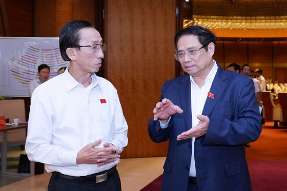 Thủ tướng Phạm Minh Chính trao đổi với đại biểu Quốc hội Trần Hoàng Ngân bên lề phiên thảo luận về tình hình thực hiện kế hoạch phát triển kinh tế - xã hội và ngân sách Nhà nước những tháng đầu năm 2023. Ảnh: VIẾT CHUNG