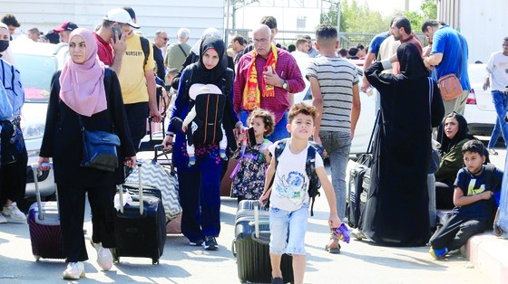 Công dân nước ngoài đổ về biên giới Gaza để chờ sang Ai Cập. Ảnh: TTXVN ảnh 1