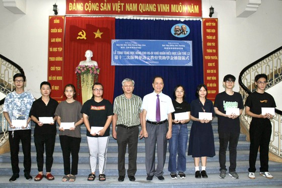 Ông Lê Viết Mạnh Hùng - Ủy viên Ban Chủ biên Báo Sài Gòn Giải Phóng Hoa Văn và ông Tô Kiến Nguyễn - Chủ tịch Hội đồng quản trị Quỹ Học bổng Đài Thương cùng trao học bổng cho sinh viên ảnh 1