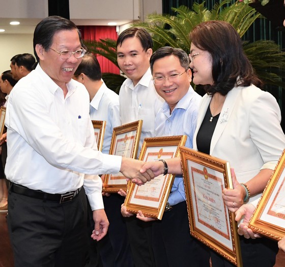 Chủ tịch UBND TPHCM Phan Văn Mãi tặng bằng khen các tập thể có thành tích xuất sắc. Ảnh: VIỆT DŨNG ảnh 1