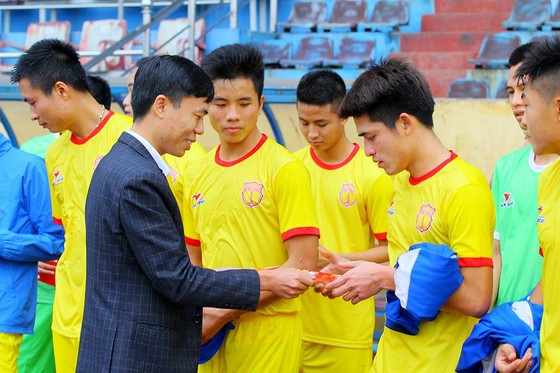 Lãnh đạo CLB Nam Định lì xì lấy hên cho các cầu thủ ở buổi tập đầu năm. Ảnh NDFC