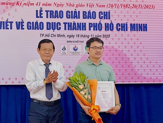 Ông Nguyễn Tấn Phong, Chủ tịch Hội Nhà báo TPHCM tặng hoa và Giấy chứng nhận đoạt giải nhất cho nhóm phóng viên Quang Huy - Thu Tâm, Báo Sài Gòn Giải Phóng. Ảnh: AN KHÁNH