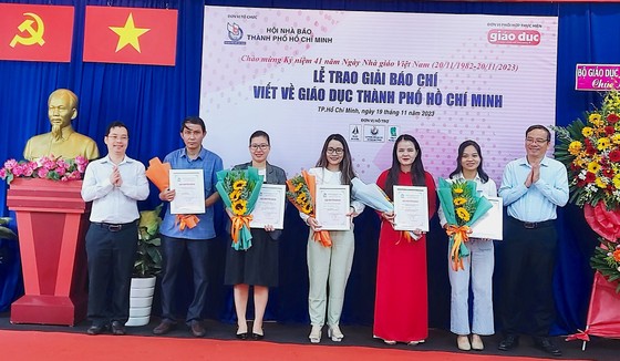 Đại diện Ban Tuyên giáo Thành ủy TPHCM và đại diện Đơn vị tài trợ tặng hoa và Giấy chứng nhận cho các tác giả đoạt giải khuyến khích. Ảnh: AN KHÁNH