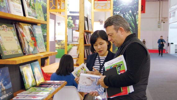 Một đối tác nước ngoài đang tìm hiểu các ấn phẩm của Việt Nam tại Hội sách Frankfurt 2019. Ảnh: HÒA LONG