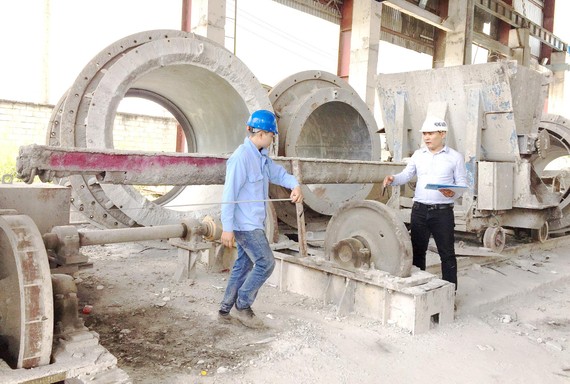 Kỹ sư Trần Quốc Toản (phải) hướng dẫn công nhân ứng dụng những cải tiến mới vào vận hành sản xuất
