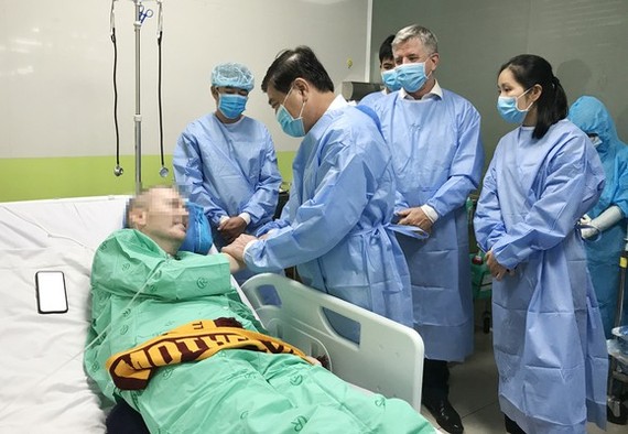 Chủ tịch UBND TPHCM Nguyễn Thành Phong thăm hỏi, động viên bệnh nhân thứ 91 – phi công người Anh tại Bệnh viện Chợ Rẫy, chiều 17-6-2020. Ảnh: HOÀNG HÙNG
