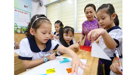 Phấn khởi chương trình phổ thông mới Cô Nguyễn Thị Thu Vân hướng dẫn học sinh lớp 1/6 Trường Tiểu học Nguyễn Bỉnh Khiêm, quận 1 bài học nhóm. Ảnh: HOÀNG HÙNG