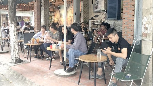 Nhiều bạn trẻ không đeo khẩu trang tại một quán cà phê