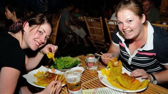 外國遊客在品嚐我國美食。（圖源：互聯網）