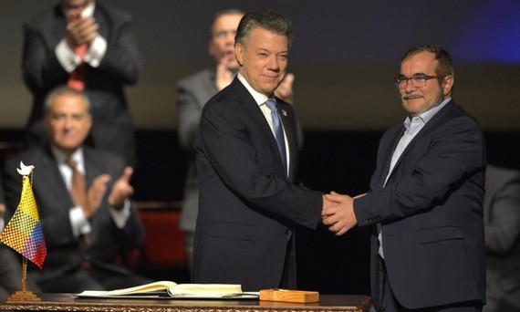 哥倫比亞總統桑托斯（左）和“哥武”領導人羅德里格·隆多尼奧·埃切韋里在新和平協議簽署儀式上握手。(圖源：互聯網)