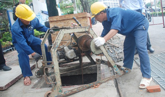 都市排水公司工人在阮友景街疏通溝渠。（圖源：明慧）