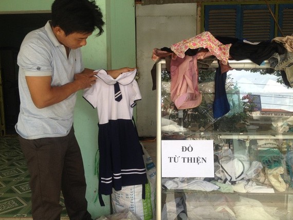 潘青峰整理慈善物品櫃裏的衣服。