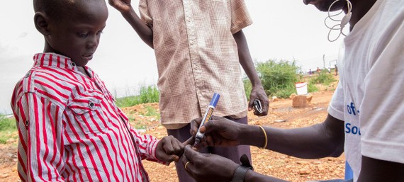 南蘇丹一名健康工作者為一名兒童接種了霍​​亂疫苗後在他手上做了記號。（圖源：聯合國）