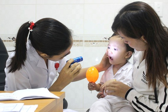 醫生正在為兒童檢查手足口病。 （圖源：秋霜）