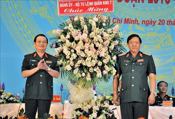 第七軍區政委陳懷忠海軍上將（左）代表第七軍區政委向市司令部贈送鮮花表示祝賀。（圖源：越通社）