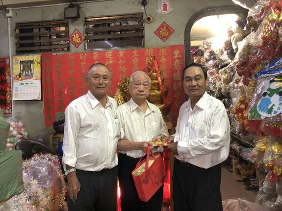 副會長黃炳友（左）、許永成（右）贈送禮物給楊光澤校友。