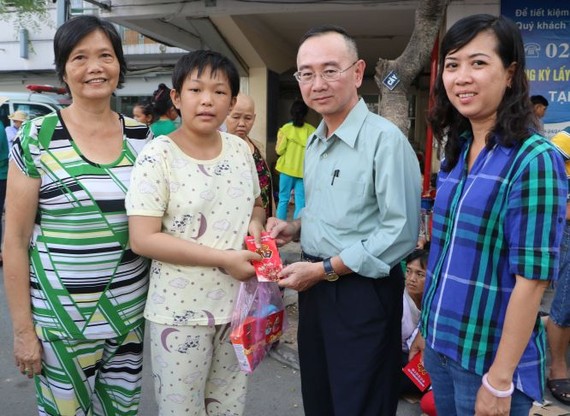 本報編委兼編輯部主任范興(右二)向患上腦腫瘤的華人病童陳雅珍贈送禮物代金。