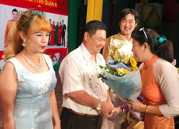 第六郡婦聯會主席梁青竹向華人熱心人士贈花致謝。