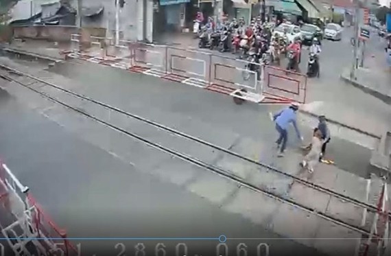 面臨列車直衝而來的一剎那，兩名鐵路女值班員奮不顧身把老人拖出了危險區域。（圖源：監控視頻截圖）