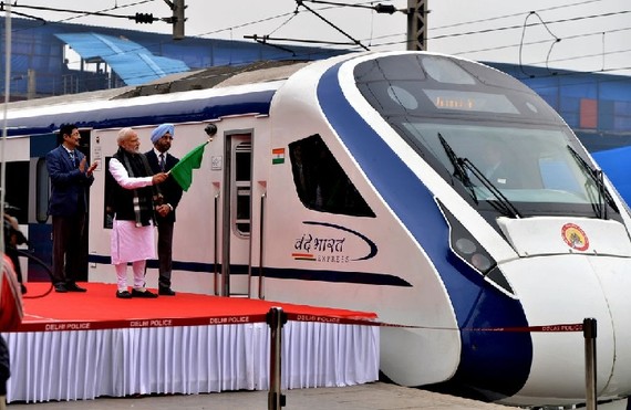 當地時間15日，在印度首都新德里，印度總理莫迪（前）在開通運營儀式上手持指揮列車的旗幟。（圖源：互聯網）