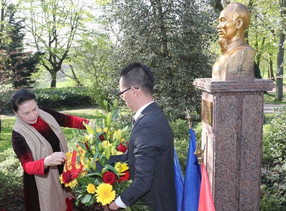 國會主席阮氏金銀（左）前往蒙特勒伊市的Montreau公園向胡志明主席塑像敬獻花圈。（圖源：越通社）