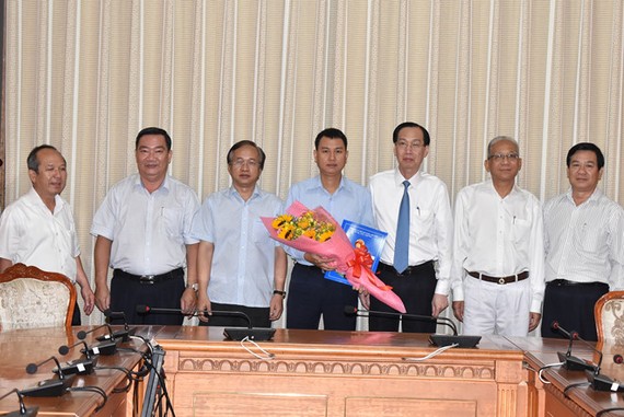 新任第二郡人委會副主席阮白黃鳳（中）接過人事委任《決定》和鮮花祝賀後與市領導合照。（圖源：Đ.Quân）
