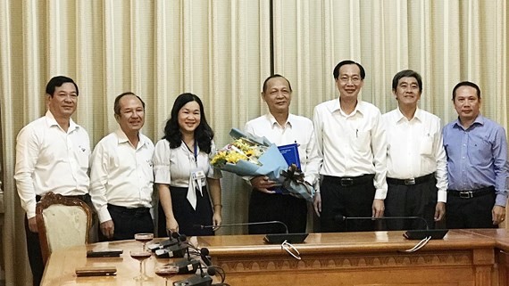 市人委會常務副主席黎清廉(右三)向阮春水同志(中)頒發退休《決定》。（圖源：孟和）