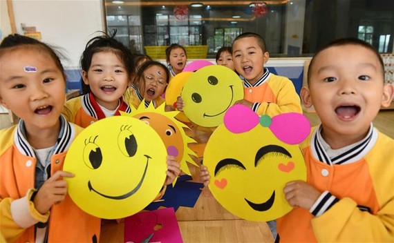 一家幼稚園的孩子在展示笑臉卡。（圖源：新華社）