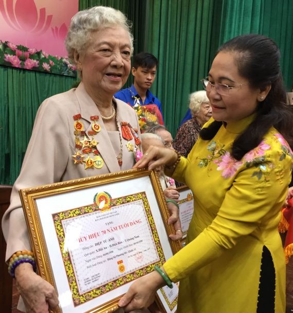 市人民議會主席阮氏麗(右)向葉秀英 大娘頒贈70黨齡紀念章。