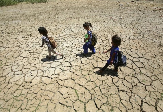 當地時間2019年5月30日，印控克什米爾地區查謨，印度多地高溫，兒童行走經過乾涸的池塘，土地龜裂。（圖源：互聯網）