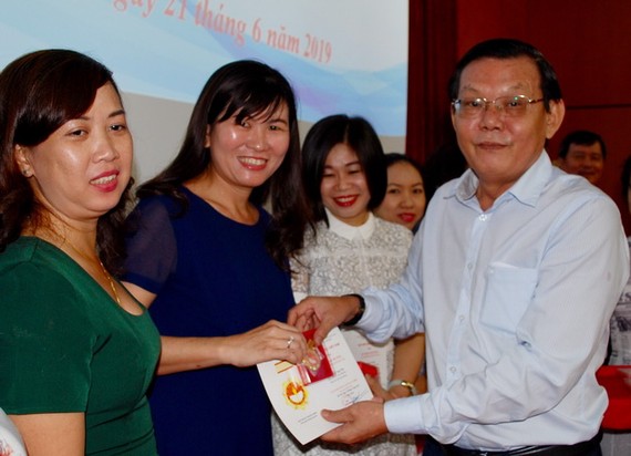 《西貢解放報》總編輯阮晉豐向本報幹部頒發紀念章。
