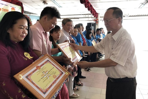 穗城會館理事長盧耀南向越華模範家庭頒發獎狀。