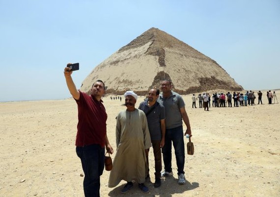 7月13日，人們在埃及首都開羅以南的彎曲金字塔前拍照。（圖源：新華社）