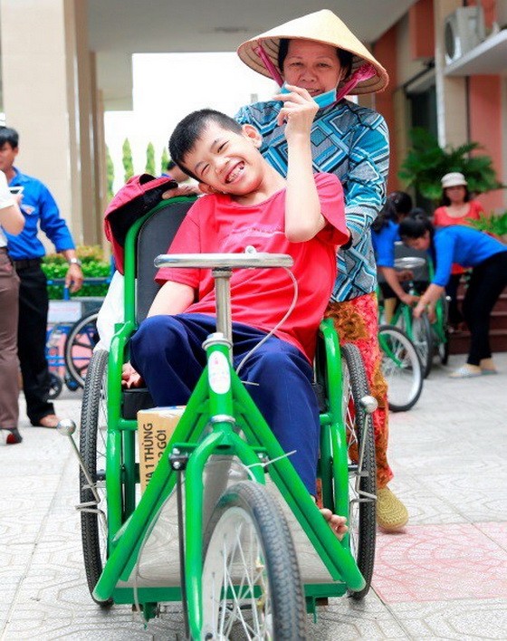 隆安省一名落葉劑受害少兒在獲贈手搖輪椅後的喜悅。