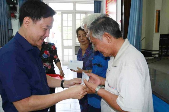 郡越南祖國陣線委員會主席黎晉才贈送 禮物給長者。