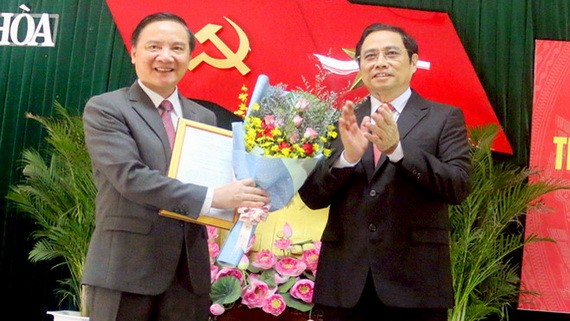 中央組織部長范明政代表黨中央政治局向阮克定同志（左）頒授人事委任《決定》並送鮮花祝賀。（圖源：安平）