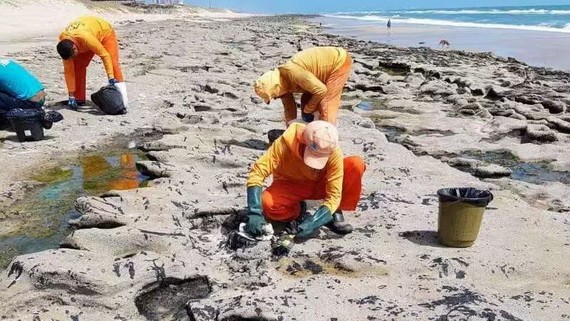 清理人員在處理沙灘表面的有毒原油。（圖源：視頻截圖）