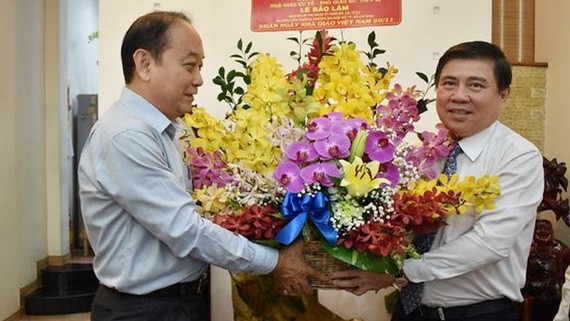 市人委會主席阮成鋒（右）向黎保霖老師贈送鮮花祝賀。（圖源：TL）