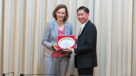 市人委會副主席陳永線（右）向奧地利聯邦經濟商會副秘書長瑪麗安娜‧庫納贈送紀念品。（圖源：VOH）