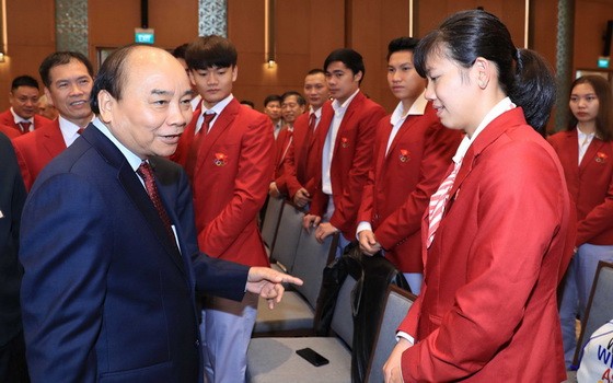 政府總理阮春福（前左）與運動員交流。（圖源：越通社）