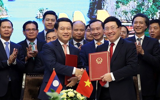 政府副總理、外交部長范平明（前右）與老撾外交部長沙倫塞‧貢瑪西簽署越南外交部與老撾外交部之間行動計劃。（圖源：外交部）