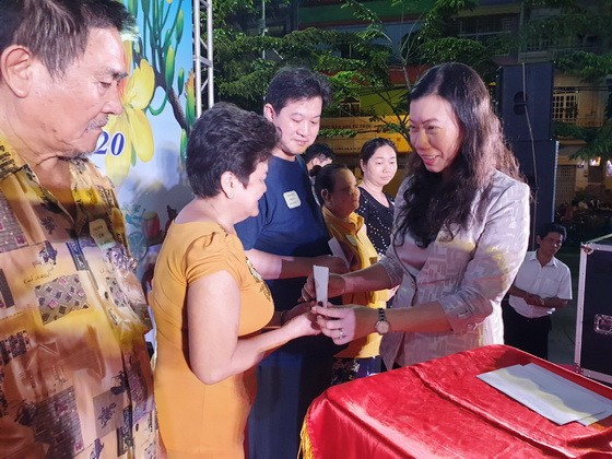 市越南祖國陣線委員會副主席趙麗慶（右）贈送禮物給貧戶。