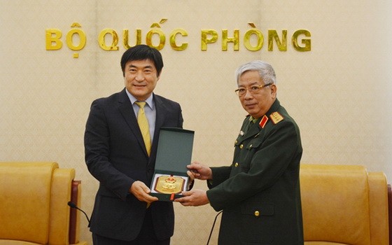 國防部副部長阮志詠上將（右）向韓國國際合作機關駐越南主任Kim Jinoh贈送紀念品。（圖源：文孝）
