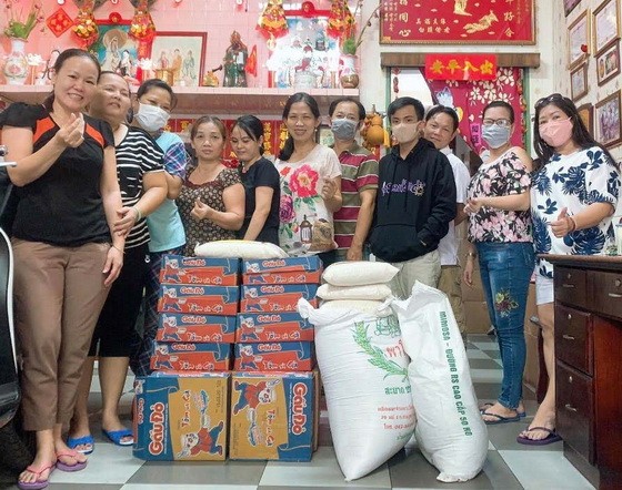 梁柳嬋(右一)與員工準備將大米和麵發送給窮人。