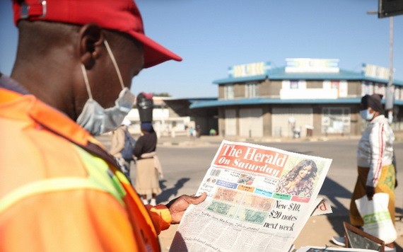 5月16日，在津巴布韋首都哈拉雷，市民瀏覽刊登10元和20元面值的新津巴布韋元票樣的報紙。（圖源：新華社）