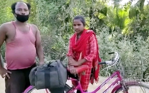 庫瑪里（右）騎單車載著受傷父親回家鄉。（圖源：互聯網）