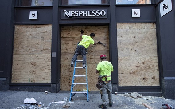 應對示威者從被砸毀的店舖，工人對一家店舖的櫥窗進行加固。（圖源：AP）