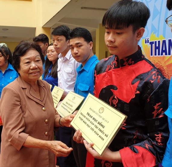 第五郡勵學會主席李金梅向華人優秀生頒發獎助學金。