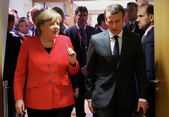 德國總理默克爾（左）與法國總統馬克龍交談。（圖源：新華社）