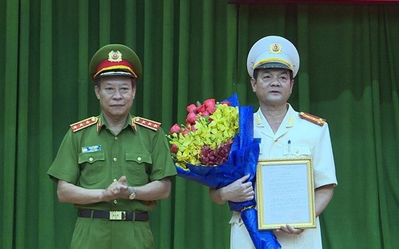 公安部副部長黎貴王向黎鴻南大校（右）頒發人事委任《決定》並送祝賀鮮花。（圖源：H.T）